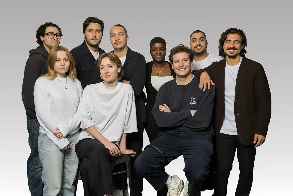 Groupe diversifié de jeunes adultes posant ensemble, avec des vêtements modernes, dans un environnement neutre.